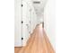 Bright hallway with neutral walls and wood floors featuring multiple doors leading to various rooms in the home at 3002 W Abdella St, Tampa, FL 33607