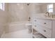 Stylish bathroom features white tile, a tub, modern fixtures, and vanity at 3008 E 38Th Ave, Tampa, FL 33610