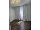 This bedroom features dark wood flooring, white walls, and bright white curtains on the window at 3008 E 38Th Ave, Tampa, FL 33610