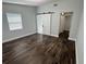 Spacious bedroom with a barn door leading to an ensuite bath and wood flooring at 3008 E 38Th Ave, Tampa, FL 33610
