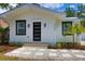 Beautiful white home with black trim, stone walkway, and manicured landscaping at 3008 E 38Th Ave, Tampa, FL 33610