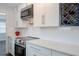Stylish kitchen with white cabinets, stainless steel appliances, and modern lighting at 3008 E 38Th Ave, Tampa, FL 33610