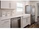 Bright kitchen with white cabinets, stainless steel appliances, and a farm-style sink at 3008 E 38Th Ave, Tampa, FL 33610