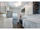 Elegant kitchen featuring white cabinetry, a stainless steel refrigerator, and hardwood flooring at 3008 E 38Th Ave, Tampa, FL 33610