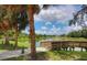 Scenic pond view featuring lush green grass and a wooden walkway at 3008 E 38Th Ave, Tampa, FL 33610