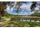 Scenic pond view featuring lush green grass and a wooden walkway at 3008 E 38Th Ave, Tampa, FL 33610