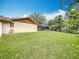 Large backyard with green grass, pool and screened-in patio, and a privacy fence at 3093 Hillside Ln, Safety Harbor, FL 34695
