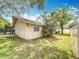 Backyard view of the home's exterior and screened in lanai and lush lawn at 3093 Hillside Ln, Safety Harbor, FL 34695