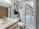 Bathroom with a white vanity, beige sink, and toilet near a door with a view of the pool at 3093 Hillside Ln, Safety Harbor, FL 34695