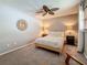Bedroom features a queen bed, ceiling fan, carpeted floors and sunburst mirror at 3093 Hillside Ln, Safety Harbor, FL 34695