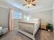 Cozy bedroom with a white bed, pink curtains, a nightstand, a ceiling fan, and soft carpeting at 3093 Hillside Ln, Safety Harbor, FL 34695