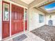 Inviting front entrance features a red door with sidelights and a 'Be Our Guest' welcome mat at 3093 Hillside Ln, Safety Harbor, FL 34695