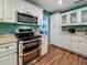 Kitchen features stainless steel appliances, a breakfast bar, and wood-look floors at 3093 Hillside Ln, Safety Harbor, FL 34695