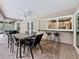 Covered outdoor dining area featuring a full kitchen window with barstool seating and ceiling fan for maximum comfort at 3093 Hillside Ln, Safety Harbor, FL 34695