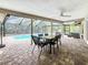 Covered patio with a dining table and chairs, fan, brick pavers, and view of the swimming pool at 3093 Hillside Ln, Safety Harbor, FL 34695