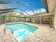 Outdoor pool with screened enclosure, featuring dining area, kitchen pass-through, and lounge seating at 3093 Hillside Ln, Safety Harbor, FL 34695