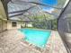 Screened swimming pool area with brick flooring and lush landscaping, creating a private outdoor oasis at 3093 Hillside Ln, Safety Harbor, FL 34695