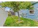 Backyard view featuring a large tree, green grass, and a screened patio at 378 Wood Chuck Ave, Tarpon Springs, FL 34689