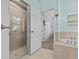 The bathroom features a tiled walk-in shower, soaking tub, and a door to the bedroom, providing comfort at 378 Wood Chuck Ave, Tarpon Springs, FL 34689