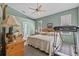 Bedroom with treadmill, dresser, ceiling fan, and en suite bathroom, offering comfortable convenience at 378 Wood Chuck Ave, Tarpon Springs, FL 34689