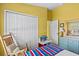 Cheerful yellow bedroom with a rocking chair and a closet for storage at 378 Wood Chuck Ave, Tarpon Springs, FL 34689