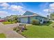 Exterior view of blue single-story home with three-car garage and lush landscaping on a sunny day at 378 Wood Chuck Ave, Tarpon Springs, FL 34689