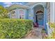 Inviting front entrance with a colorful wreath, vibrant plants, and a cozy red chair at 378 Wood Chuck Ave, Tarpon Springs, FL 34689