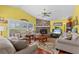 Cozy living room with a brick fireplace, large windows with shutters, and hardwood floors providing an inviting atmosphere at 378 Wood Chuck Ave, Tarpon Springs, FL 34689