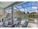 Covered patio with a table and chairs, overlooking a screened pool and backyard at 378 Wood Chuck Ave, Tarpon Springs, FL 34689