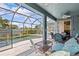 Screened-in patio features comfortable seating and overlooks a sparkling pool at 378 Wood Chuck Ave, Tarpon Springs, FL 34689
