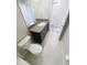 Bright bathroom features a single vanity, a toilet and white tiling at 3810 Romano Busciglio St, Tampa, FL 33619
