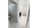 Bright bathroom offers light gray walls and tile flooring, toilet, sink, with walk-in closet at 3810 Romano Busciglio St, Tampa, FL 33619