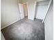 Bedroom featuring neutral paint, gray carpet, and a closet with ample storage space at 3810 Romano Busciglio St, Tampa, FL 33619