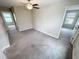 Carpeted bedroom showcases light gray walls, two windows, and a ceiling fan at 3810 Romano Busciglio St, Tampa, FL 33619