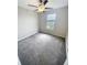 Cozy bedroom featuring neutral paint, gray carpet, a ceiling fan, and a window providing natural light at 3810 Romano Busciglio St, Tampa, FL 33619