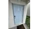 Light blue front door with modern hardware and welcoming doormat on a white house at 3810 Romano Busciglio St, Tampa, FL 33619