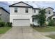 Two-story home featuring a two-car garage, light blue front door and manicured landscaping at 3810 Romano Busciglio St, Tampa, FL 33619