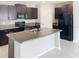 Kitchen island with dark cabinets, granite countertops, and stainless steel appliances at 3810 Romano Busciglio St, Tampa, FL 33619