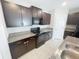 Modern kitchen showcasing granite countertops, dark cabinetry, stainless steel appliances, and tile flooring at 3810 Romano Busciglio St, Tampa, FL 33619