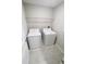 Convenient laundry room equipped with a washer, dryer, and overhead storage shelf at 3810 Romano Busciglio St, Tampa, FL 33619