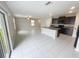 Open concept living room and kitchen with tile floors and sliding glass door at 3810 Romano Busciglio St, Tampa, FL 33619