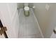 Small powder room features white tile flooring with a toilet at 3810 Romano Busciglio St, Tampa, FL 33619
