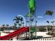 Community water feature with a red slide and large green bucket for a fun and playful outdoor experience at 3810 Romano Busciglio St, Tampa, FL 33619
