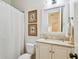 Cozy bathroom with a shower-tub combo, classic tile, and framed artwork at 4313 W Beachway Dr, Tampa, FL 33609