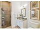 Well-lit bathroom with glass-enclosed shower, granite countertop, and decorative mirror at 4313 W Beachway Dr, Tampa, FL 33609