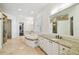 Bright primary bathroom featuring dual sinks with granite counters, soaking tub and walk-in shower at 4313 W Beachway Dr, Tampa, FL 33609