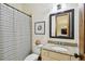 Cozy bathroom featuring granite counters, framed mirror and shower with striped curtain at 4313 W Beachway Dr, Tampa, FL 33609