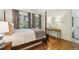 Well-lit bedroom showcasing hardwood floors, a four-poster bed, and views of the lush outdoors at 4313 W Beachway Dr, Tampa, FL 33609