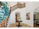 Grand foyer with elegant staircase, detailed iron railings, arched doorways and travertine tile flooring at 4313 W Beachway Dr, Tampa, FL 33609