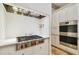 Modern kitchen with stainless steel stove top, oven, custom cabinetry, and designer backsplash at 4313 W Beachway Dr, Tampa, FL 33609